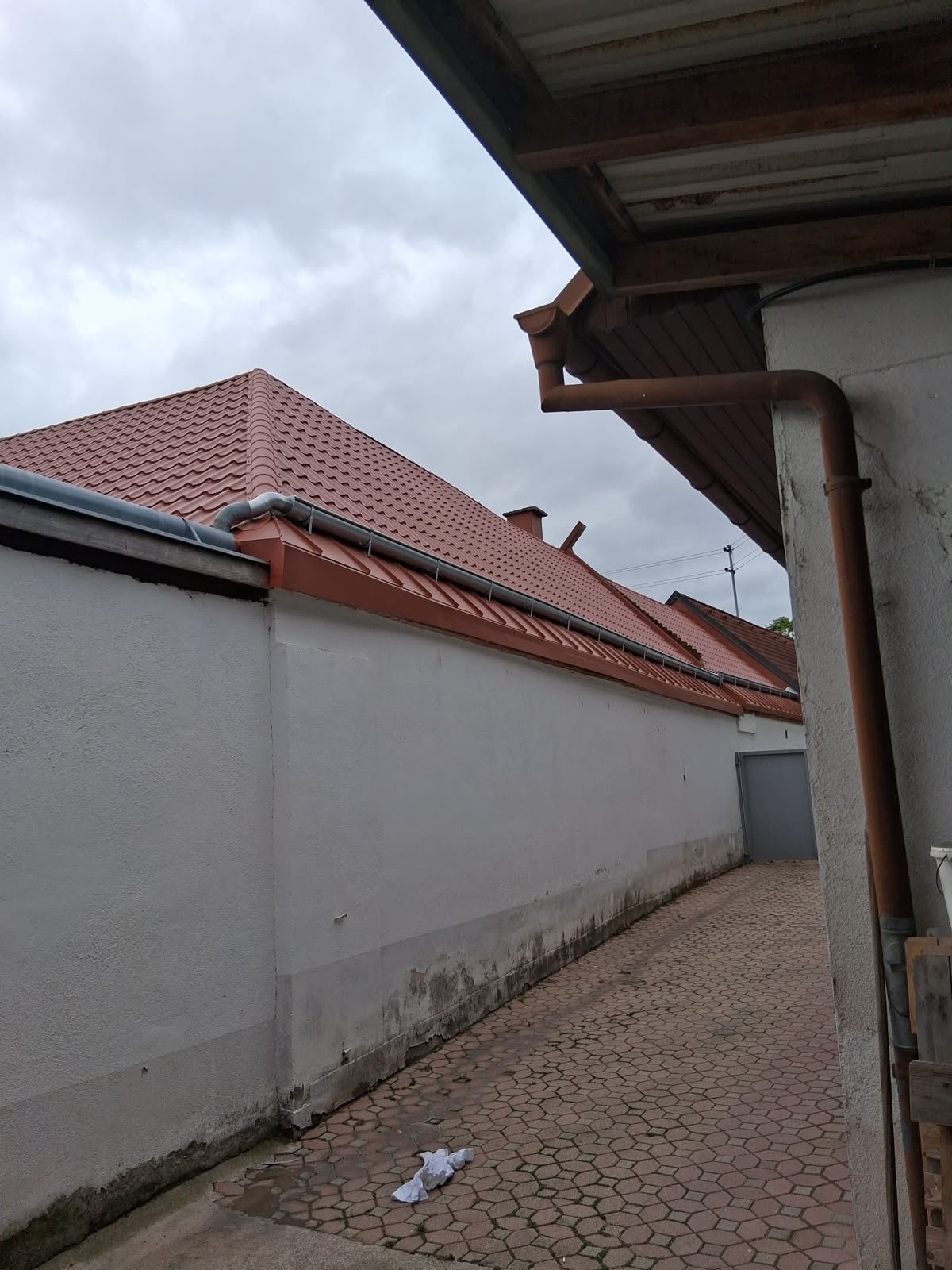 Dachrinne und Fallrohr an einem Ziegeldach